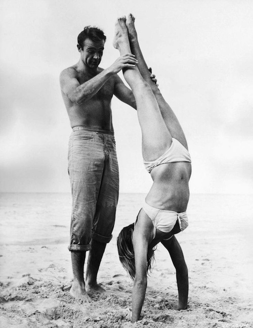 Sean Connery holds Ursula Andress while she does a handstand on the set of Dr. No, 1962